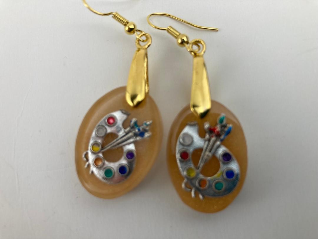 Oval shaped earrings with artist palatte charm